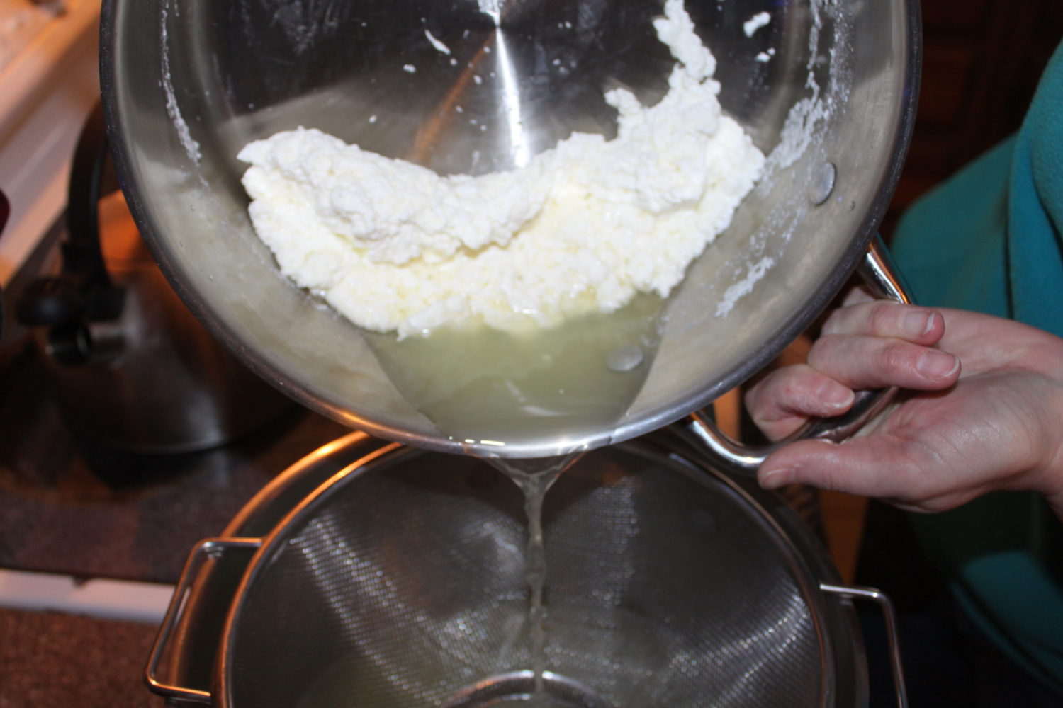 Draining the whey away from the cheese