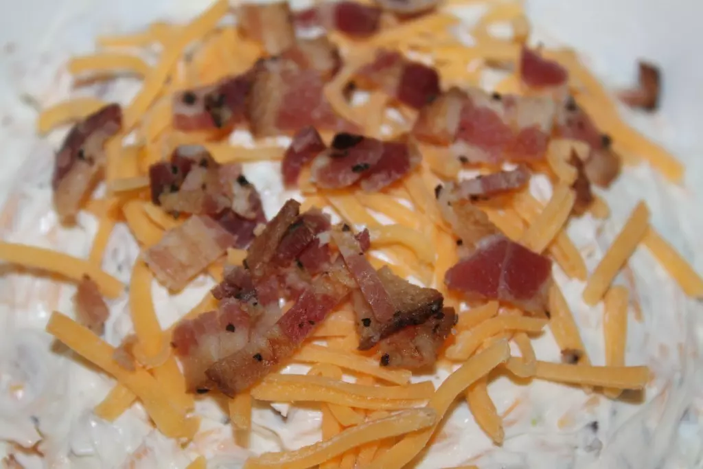 Top dip with cheese and bacon for added flavor