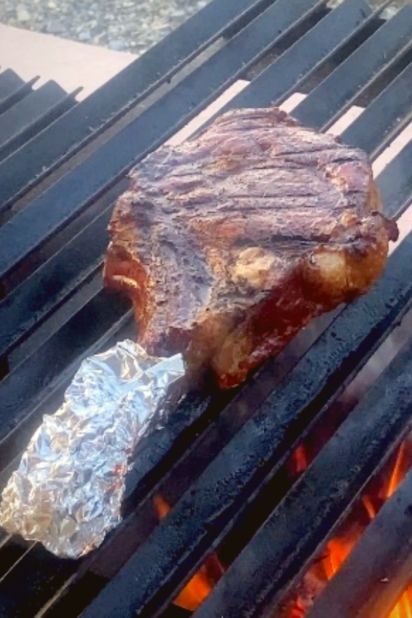 searing a tomahawk steak on a grill