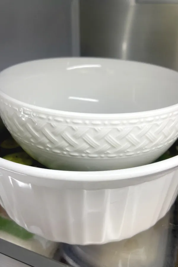 a bowl weighing down pickles in another bowl