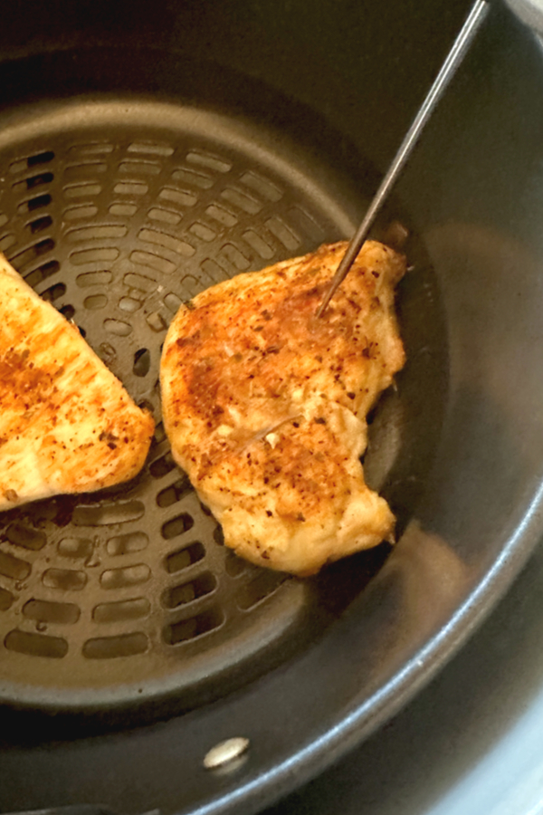 checking air fryer chicken breast with thermometer