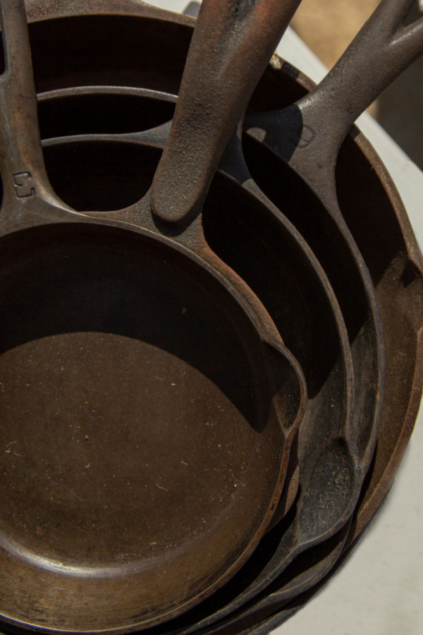 A stack of rusty cast iron skillets