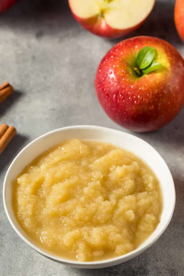A bowl of applesauce on a gray counter.