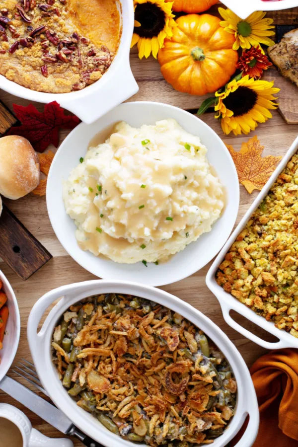 thanksgiving side dishes on food table with fluffy mashed potatoes and green bean casserole